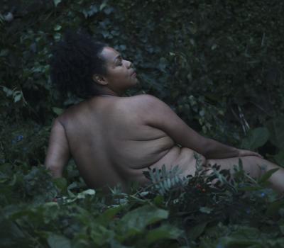 Photograph of woman at twilight in bushes